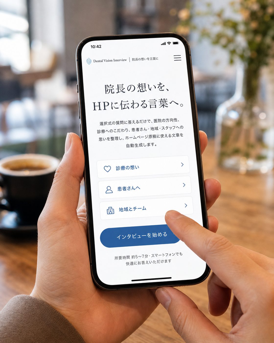 カフェのテーブルでスマートフォンに表示された院長インタビューツールの画面